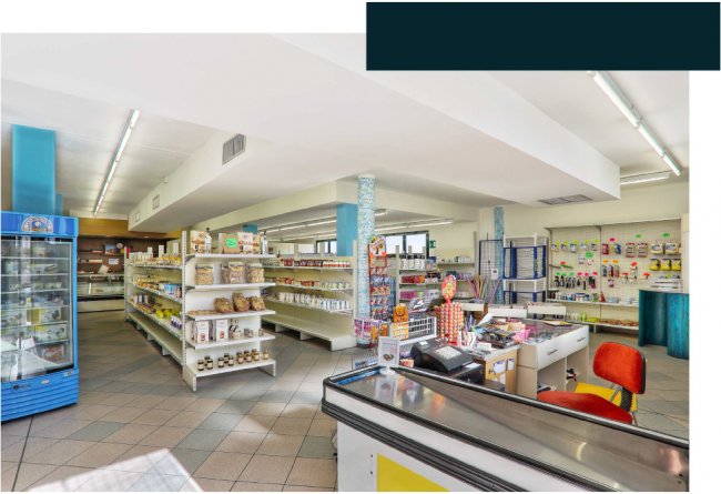 Interno di un minimarket con scaffali e cassa.