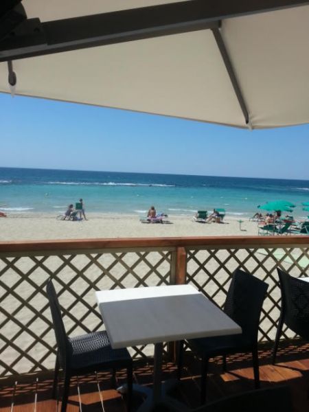 Tavolo con vista sulla spiaggia e mare azzurro.