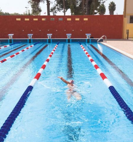Persona che nuota in una piscina a corsie.