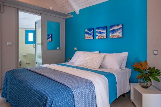 Camera da letto con parete blu e decorazioni.