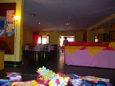 Interno di una sala ristorante con tavoli e decorazioni colorate.