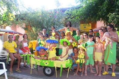 Gruppo di persone in festa con costumi colorati all'aperto.