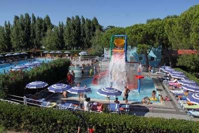 Parco acquatico con piscina, ombrelloni e giochi d’acqua.