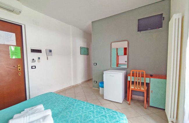 Stanza d'hotel con letto e scrivania.