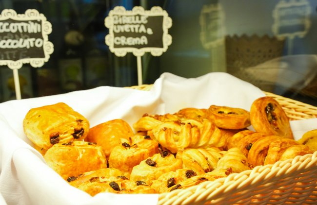 Cestino di viennoiserie, tra cui brioche e girelle con uvetta e crema.