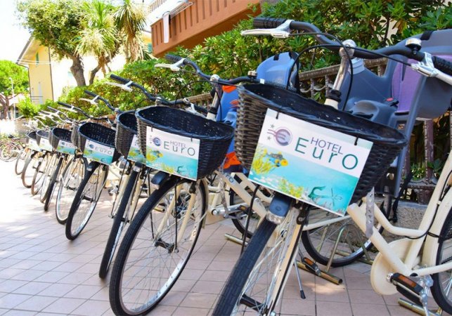 Biciclette con cestini parcheggiate vicino a un hotel.