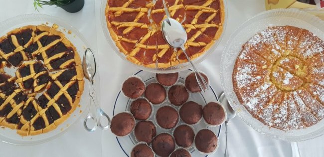 Vari dessert, tra cui crostate e muffin, su un tavolo da buffet.