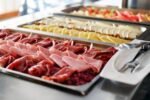 Piatti di affettati e formaggi su un buffet.