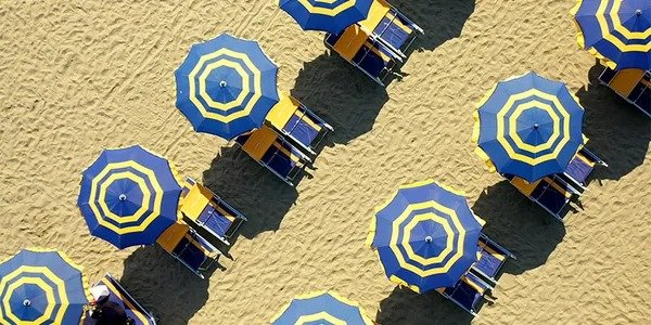 Ombrelloni blu e gialli su una spiaggia.