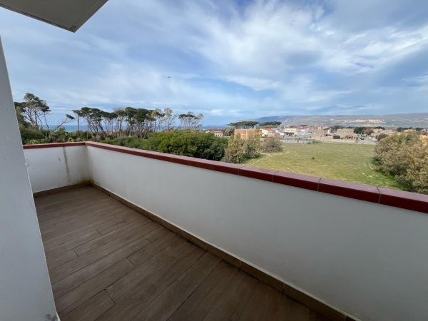 Balcone con vista su alberi e campagna.