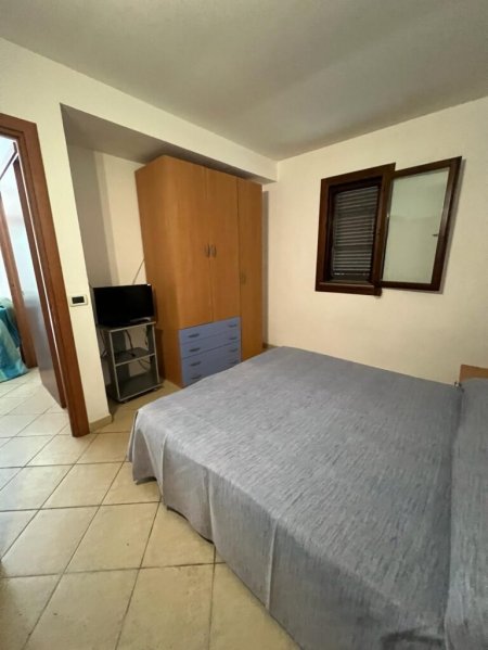 Camera con letto matrimoniale, armadio e finestra.