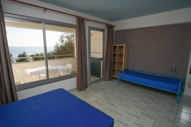 Camera con letti blu e vista mare.