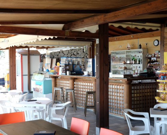 Bar all'aperto con tavoli e sedie.
