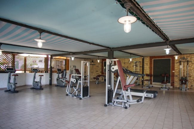 Palestra con attrezzi e biciclette in una sala coperta.