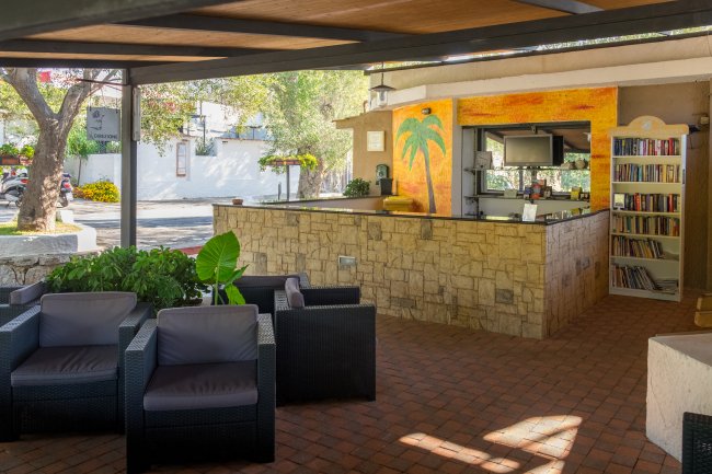 Una lounge all'aperto con divani e un bar in pietra.