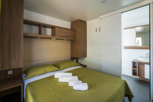 Camera da letto con letto matrimoniale e asciugamani.