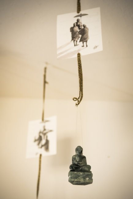 Scultura appesa di figura seduta con cartoline.
