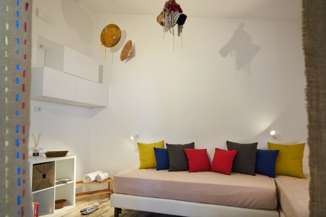 Stanza con divano e cuscini colorati, decorazioni sulle pareti.