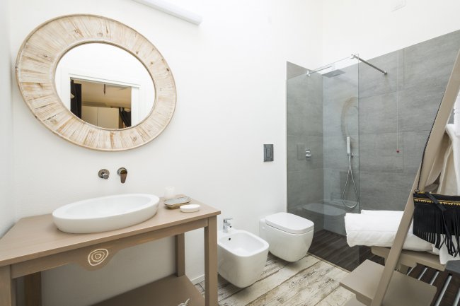 Un bagno moderno con doccia e specchio rotondo.
