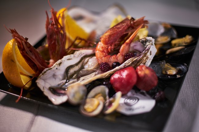Un piatto di frutti di mare con gamberi e arance.