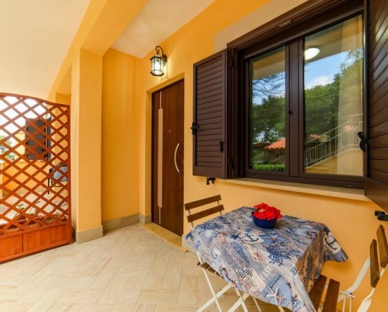 Patio con tavolino e due sedie pieghevoli.