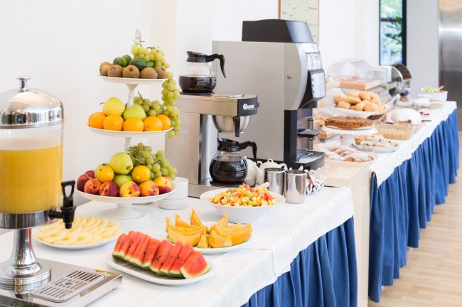 Buffet con frutta, caffè e succo d'arancia.