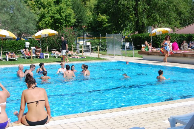 Persone nuotano in una piscina all'aperto.