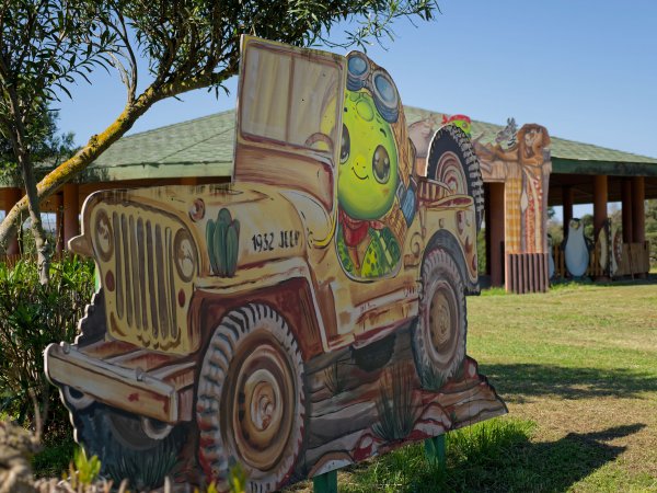 Cartonato di tartaruga su jeep gialla in un prato.