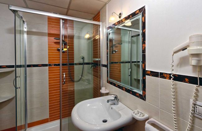 Bagno con doccia, specchio e asciugacapelli.