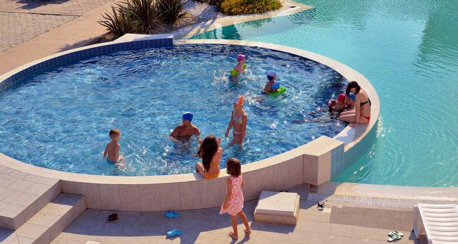 Bambini che giocano in una piscina circolare.