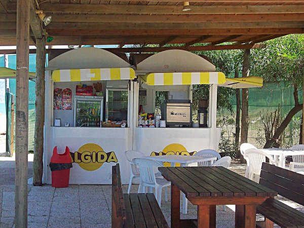Chiosco gelati Algida all'aperto con tavoli e sedie.