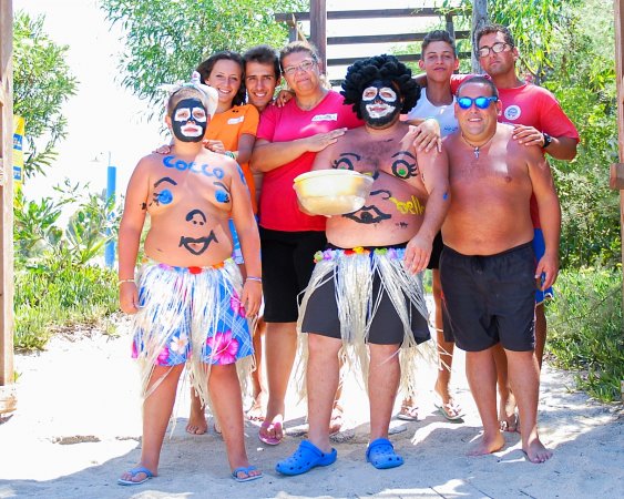 Gruppo di persone in costume su una spiaggia sotto il sole.