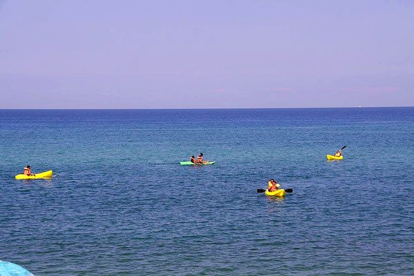Persone in kayak su un mare calmo e blu.