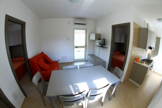 Interno moderno con divano arancione e cucina.