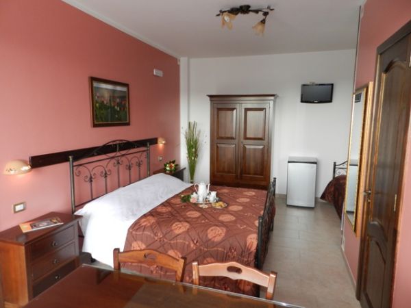 Camera con letto matrimoniale e pareti rosa.