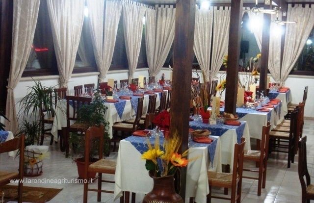 Sala da pranzo con tavoli apparecchiati.