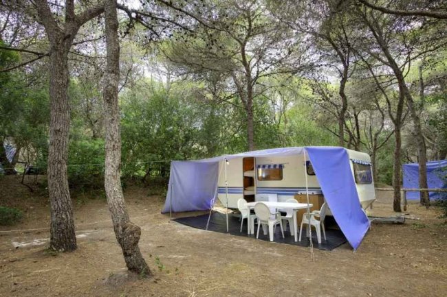 Roulotte con veranda blu e tavolo.