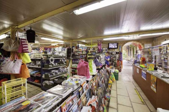 Interno di negozio con articoli vari e riviste.