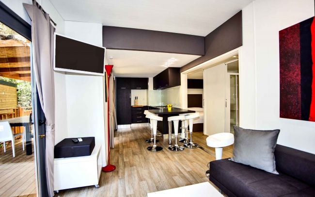 Soggiorno moderno con cucina e balcone.