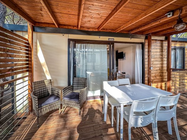 Veranda con tavolo bianco e sedie.