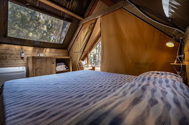 Camera di tenda glamping con letto matrimoniale.