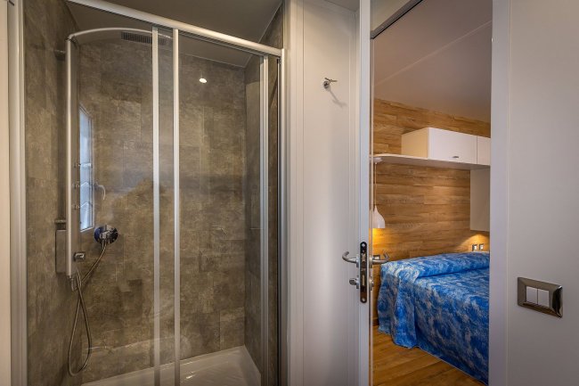 Bagno moderno con cabina doccia vista dalla camera da letto.