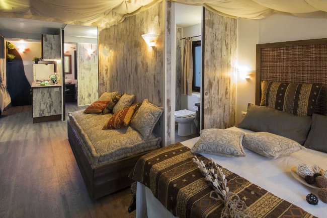 Interno elegante con letto e divano, illuminazione calda.