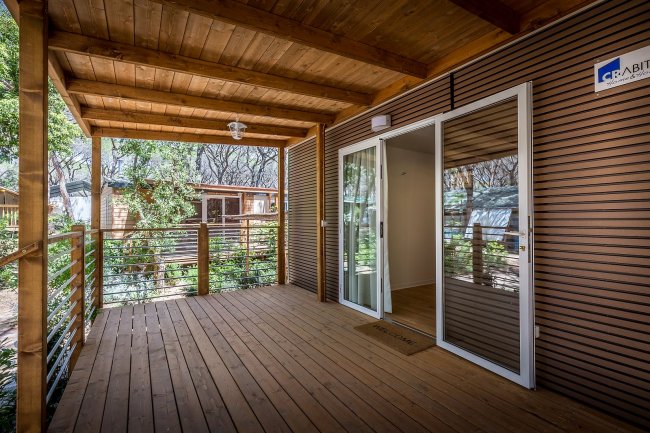 Veranda in legno con porte scorrevoli e tetto coperto.