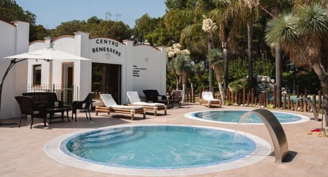 Area benessere all'aperto con piscine e sdraio.