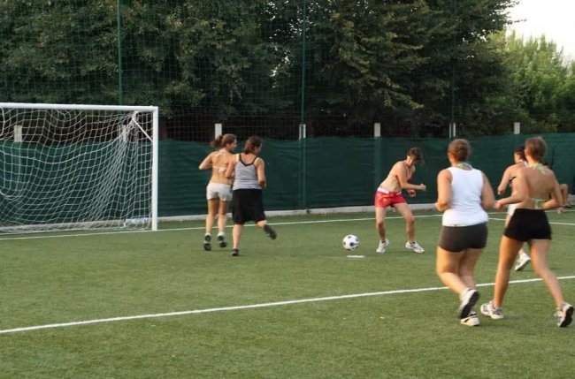 Giocatrici di calcio in un campo all'aperto vicino alla rete.