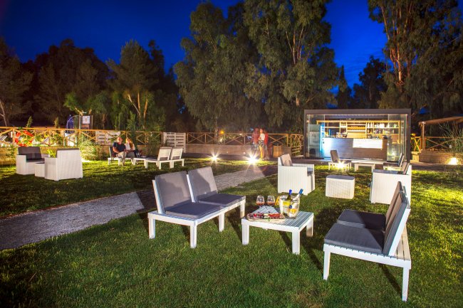 Salotto all'aperto illuminato di sera.