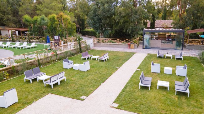 Area lounge con divani su prato verde.