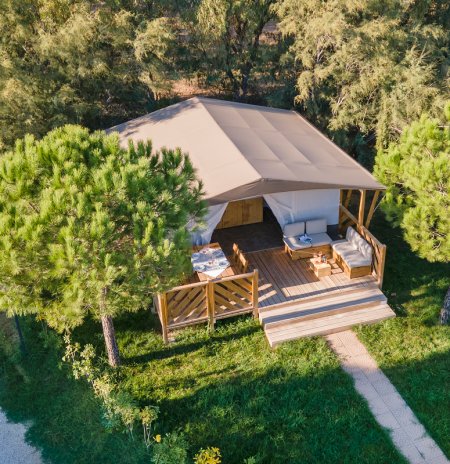 Vista aerea di tenda glamping tra alberi.