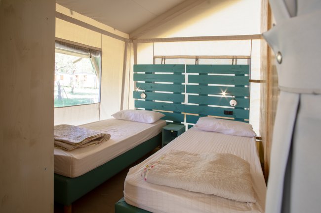 Camera con due letti singoli e testiera verde.